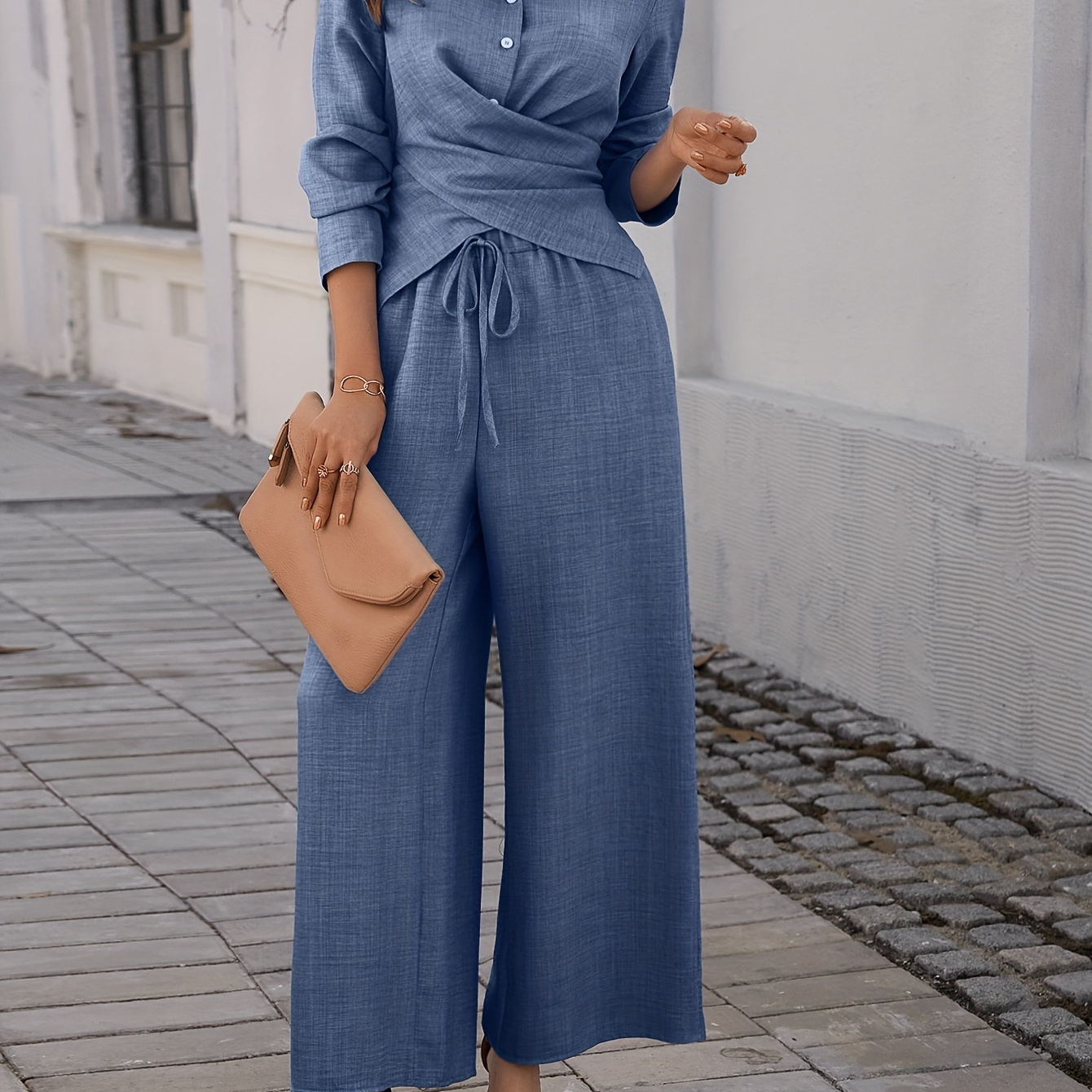 

Un ensemble pièces pour femme composé d'une chemise à manches longues de couleur unie et d'un pantalon.