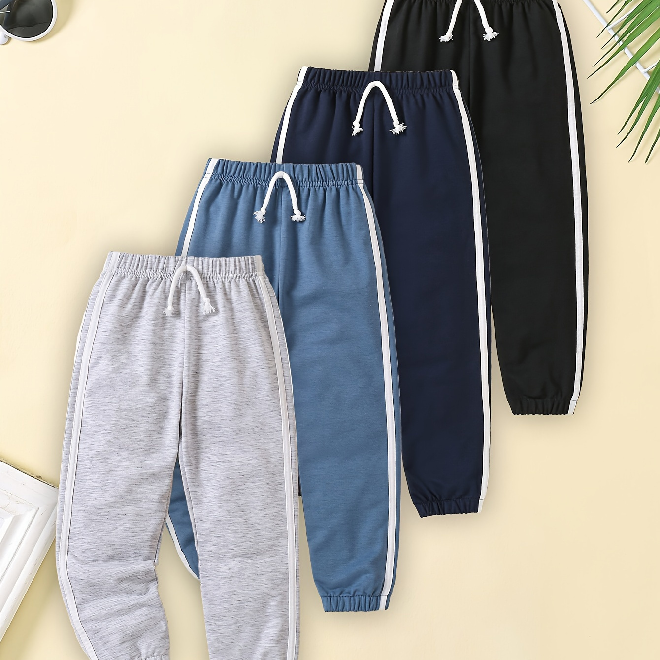 

4 pantalons de jogging décontractés pour garçons, pantalons de sport de couleur unie pour garçons et filles, design à rayures latérales, pantalons de survêtement polyvalents pour tous les jours