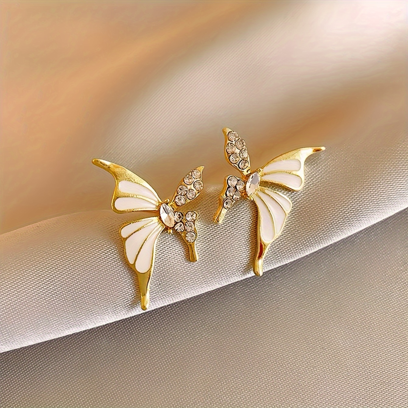 Aretes en oro laminado con diseño de mariposa con incrustaciones