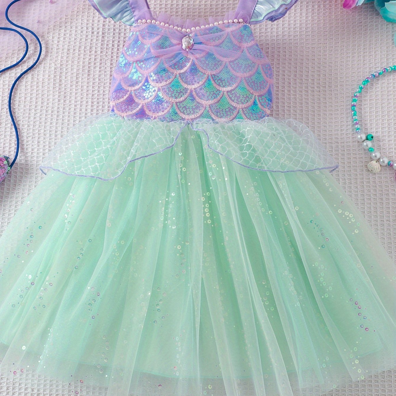 Image of A Girls' Princess Dress. The Bodice Features Purple Straps And Decoration With Fish Scale Sequins, With Pearls And Gems For Exquisite . The Skirt Is Mint Green Tulle With Small Sequins
