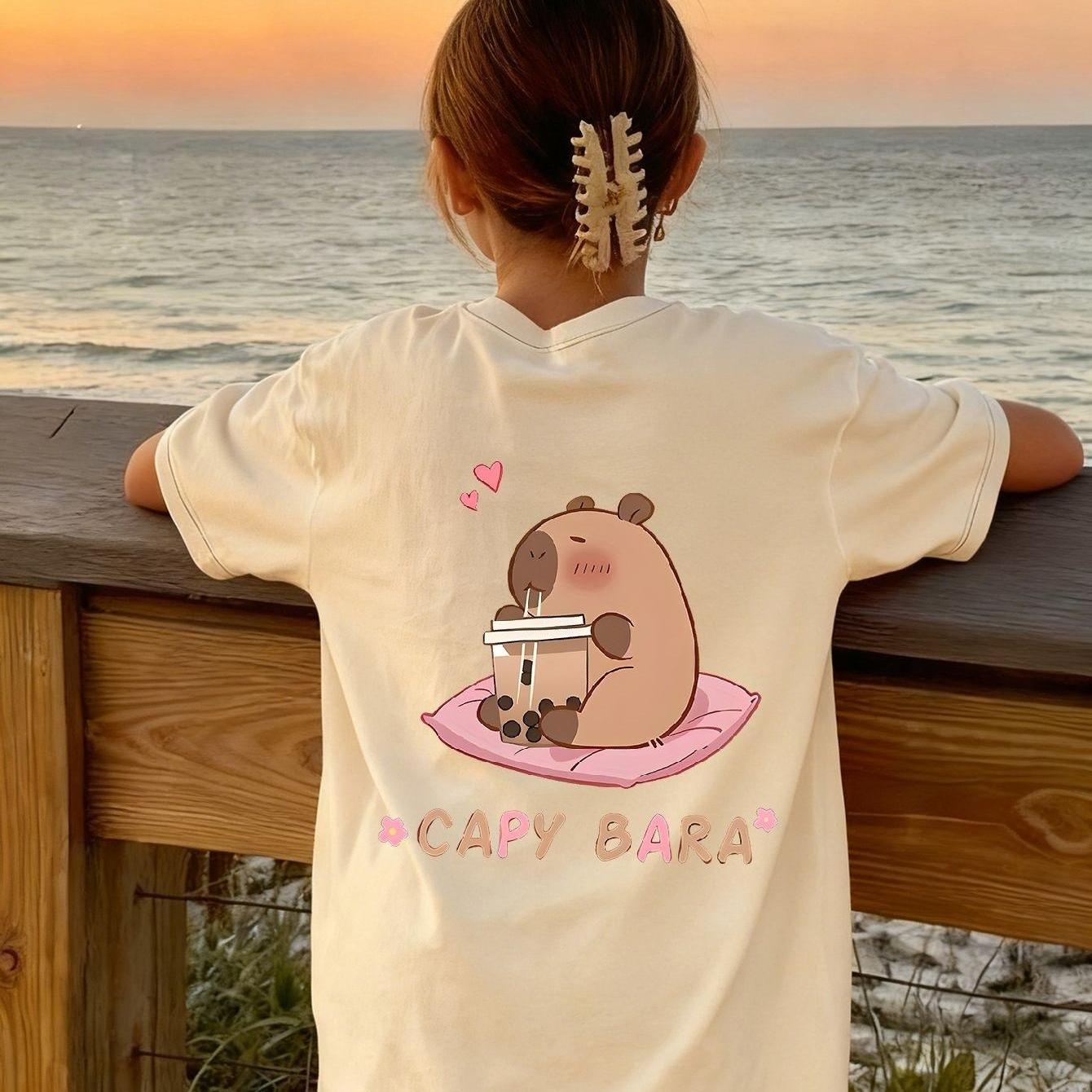 E-shop Ein kurzes T-Shirt für Mädchen - mit einem niedlichen Capybara--Print auf der Rückseite. Hergestellt aus weichem und atmungsaktivem Material, es